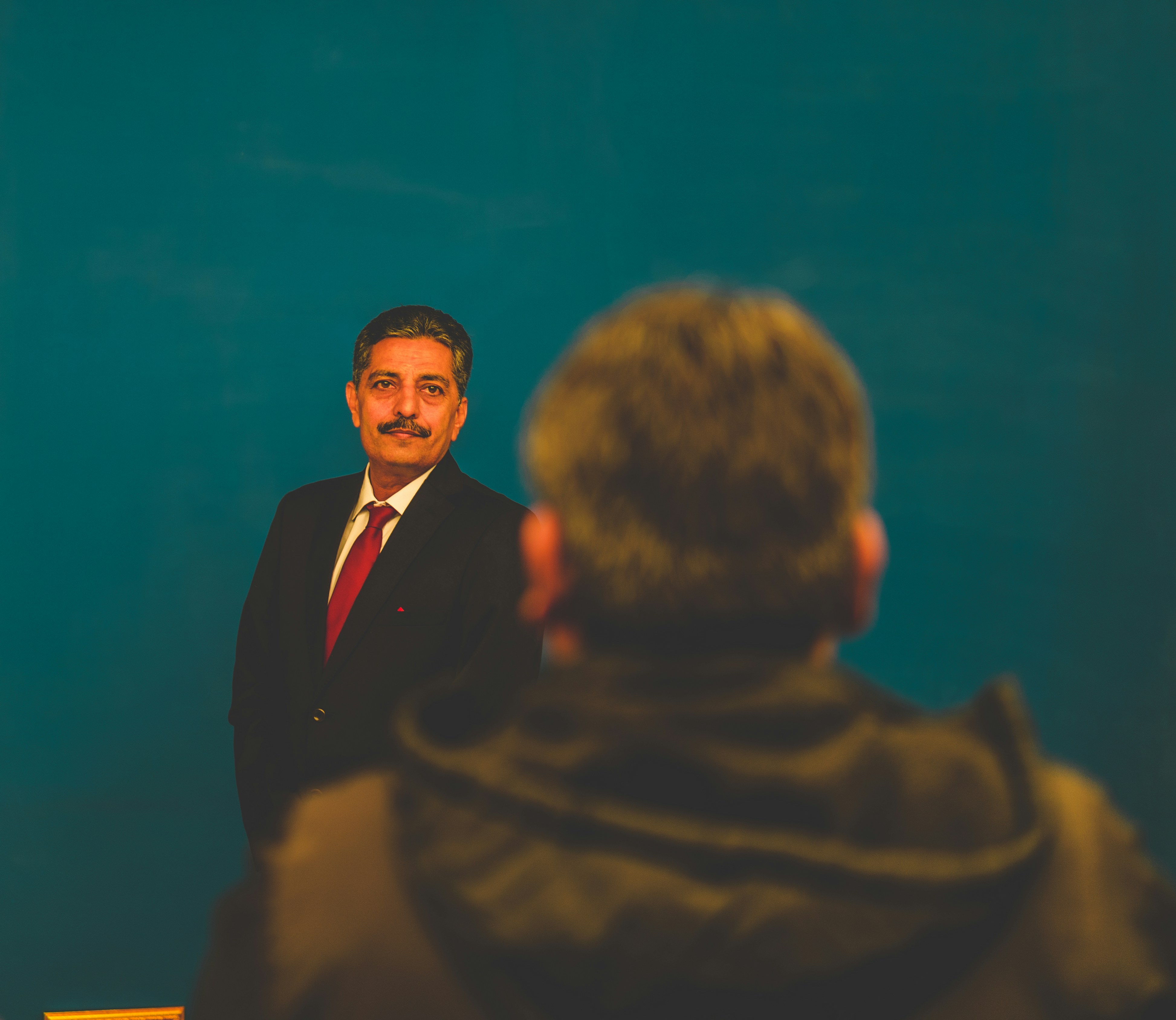man wearing black suite standing in front of another man