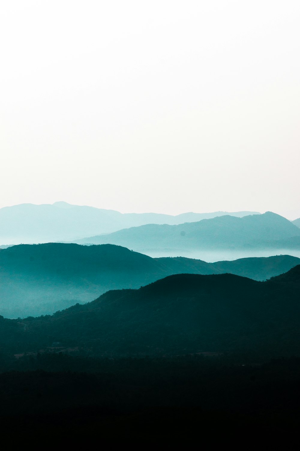 teal and black silhouette of hills