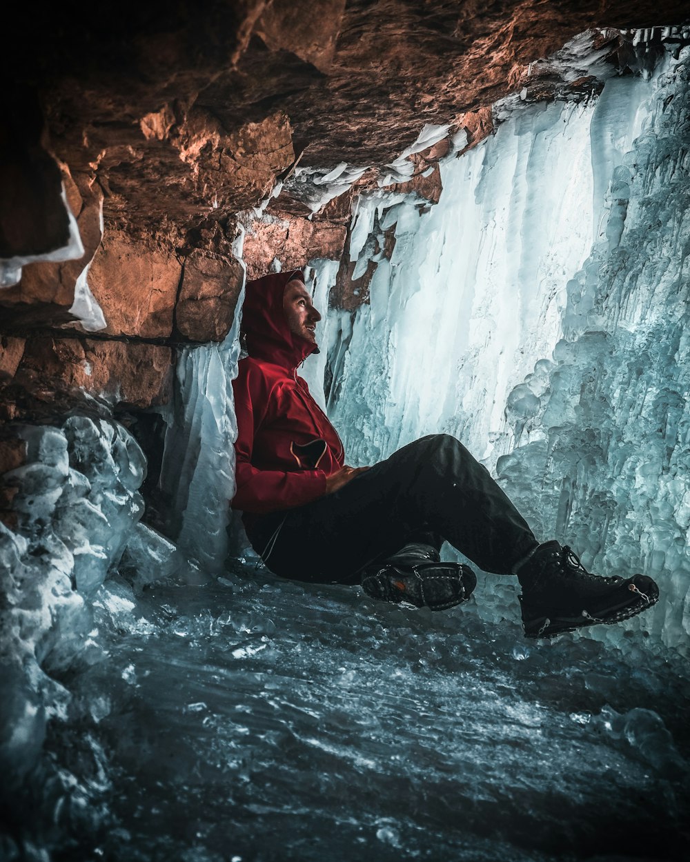 man leaning on brown rock formation