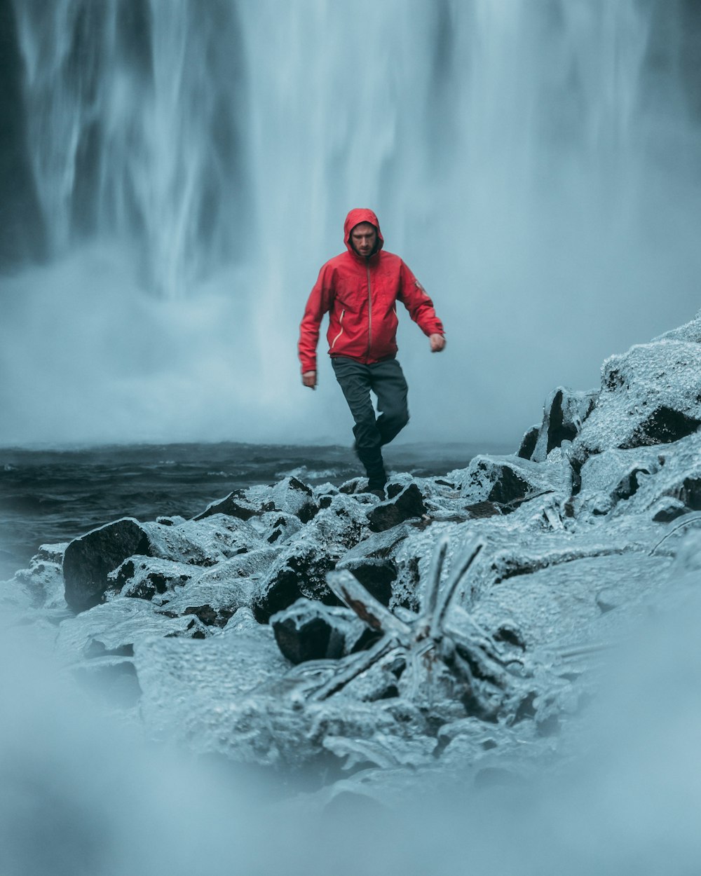 man walking near water falls during daytime