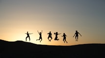 six silhouette of people jumping during sunrise