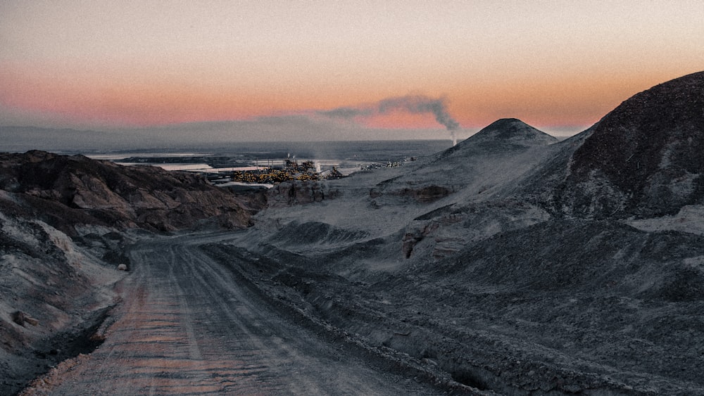 snow covered road near mountain during sunrise