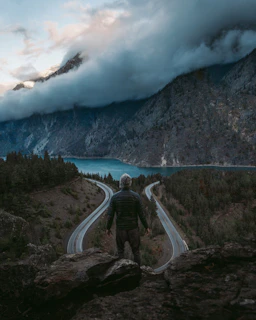 A person standing at a crossroads, looking thoughtfully toward different directions.