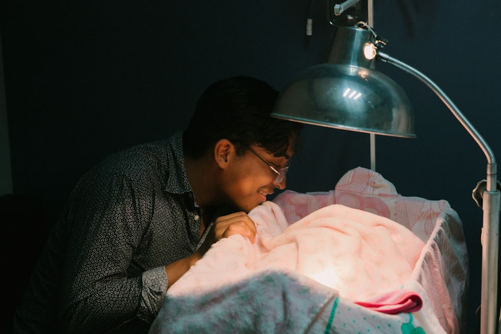 man standing beside crib