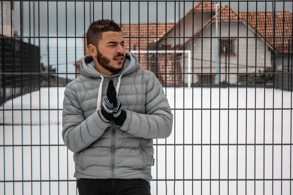 man leaning on black steel fence