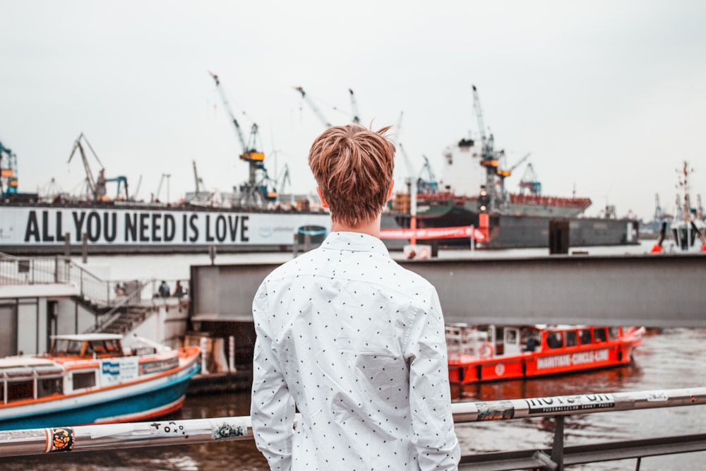 man in white dress shirt standing on near harbor