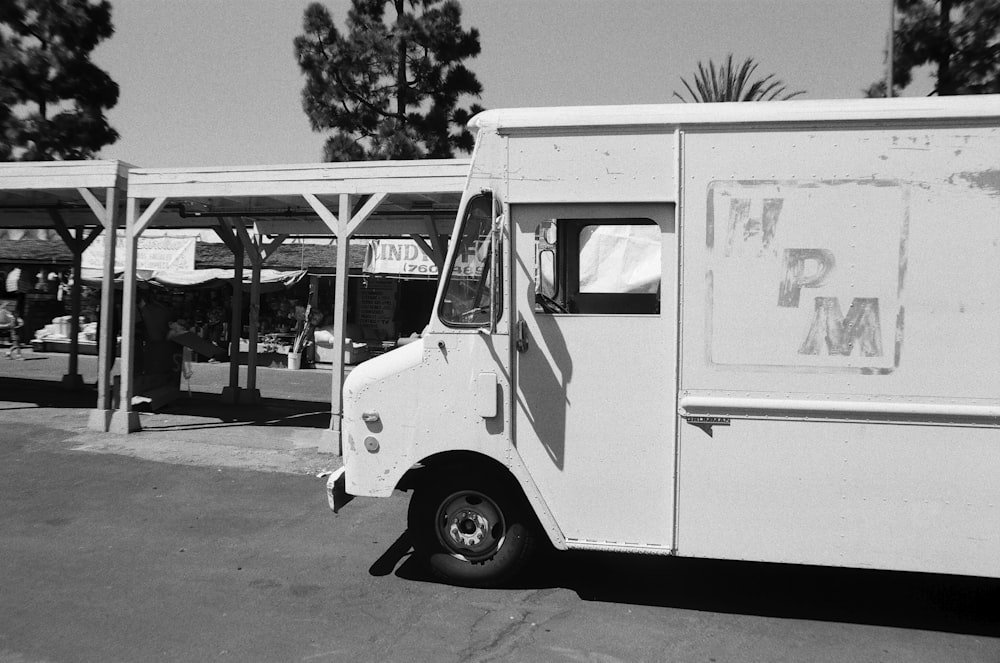 white multi-stop truck parked near shed