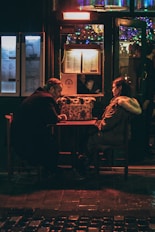 man and woman sitting in front of each other at night