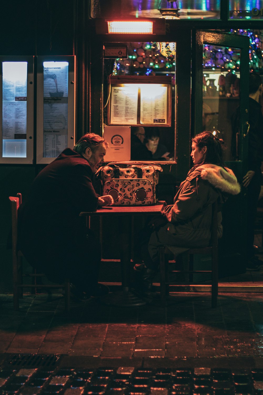 man and woman sitting in front of each other at night