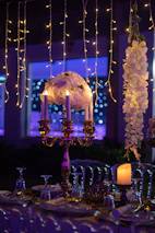 A beautifully decorated wedding reception table with pink and white accents and candles.