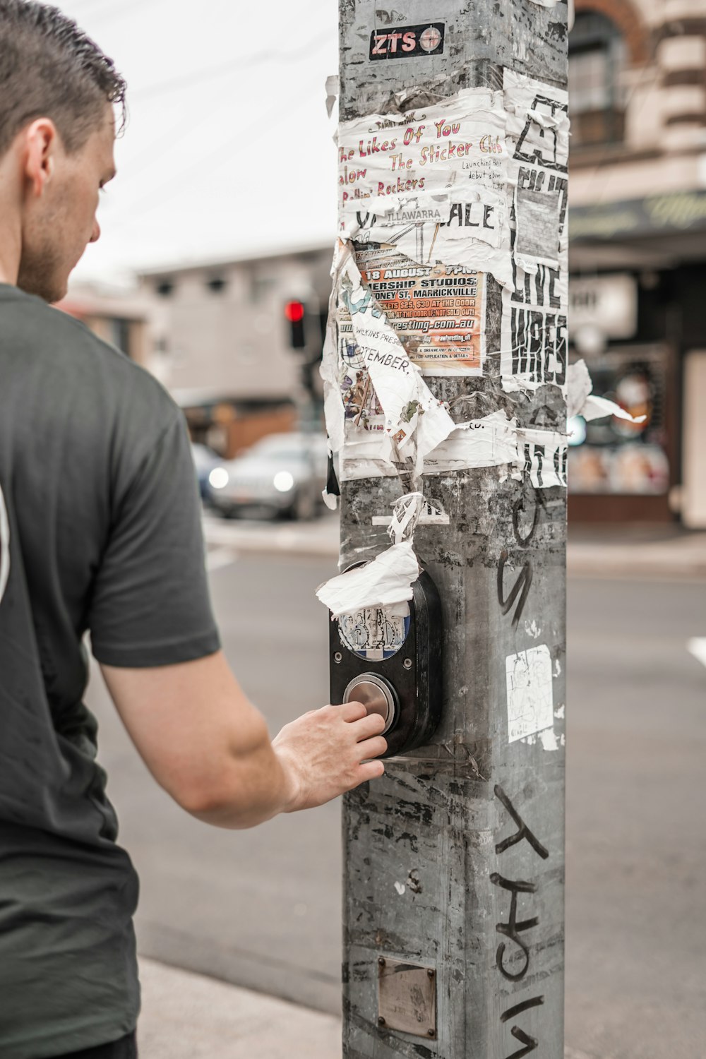 man standing beside concrete post at daytime