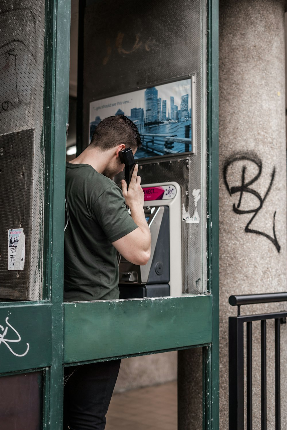 man standing while using telephone