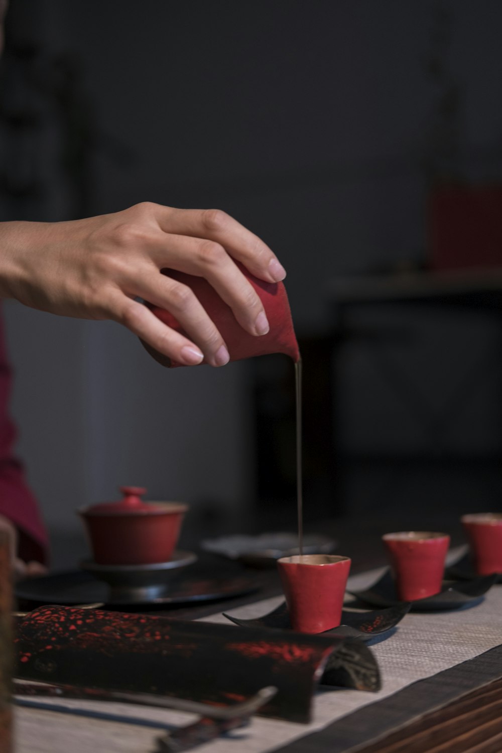 person pouring brown liquid on red cup