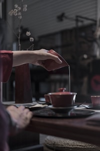 person pouring liquid on cup