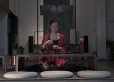 woman sitting beside table holding cup