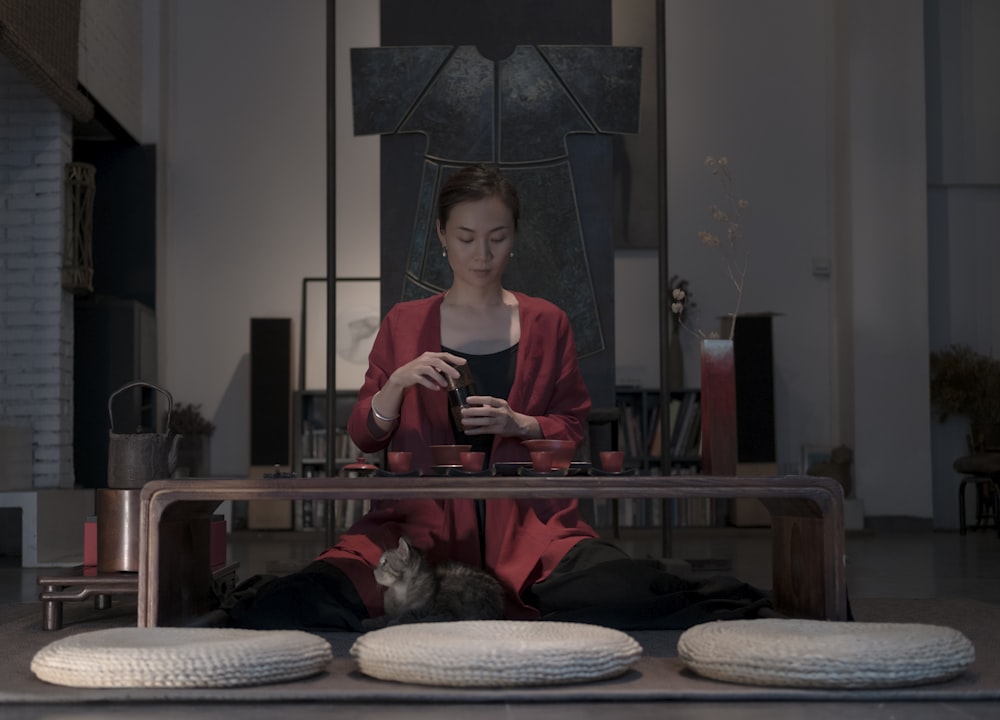 woman sitting beside table holding cup