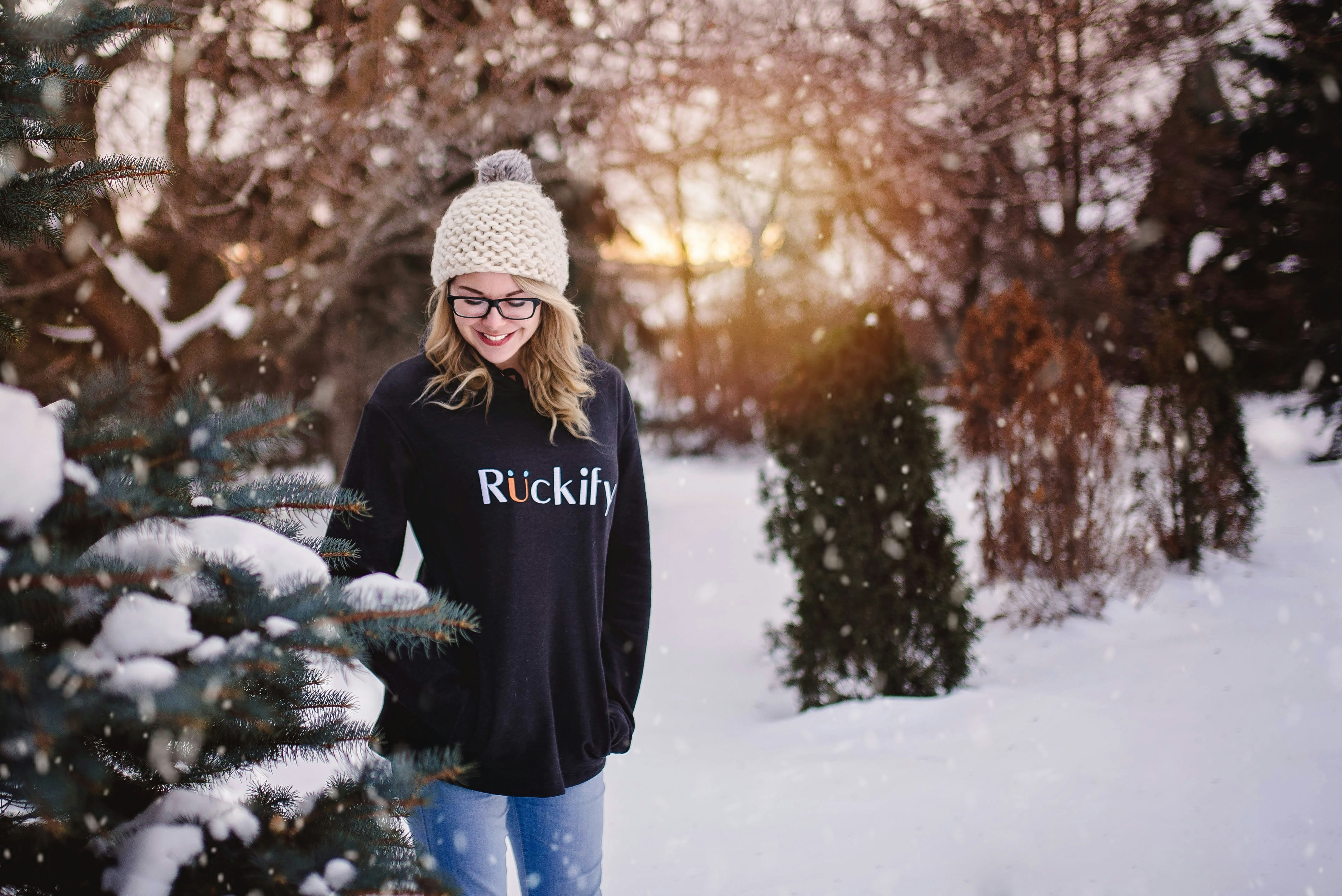 woman wearing knit cap looking at plant