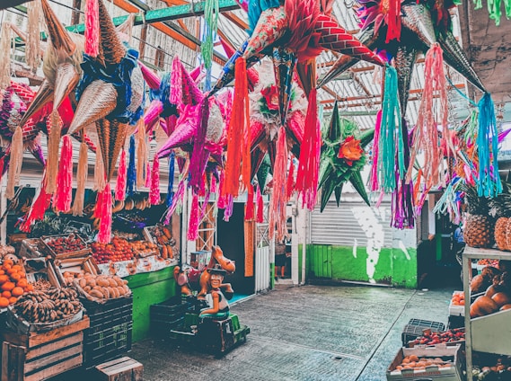 A vibrant artisan crafting a colorful traditional Mexican piñata in a festive workshop.