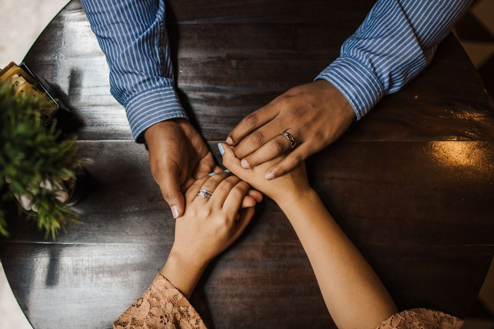 hands holding on brown wooden table