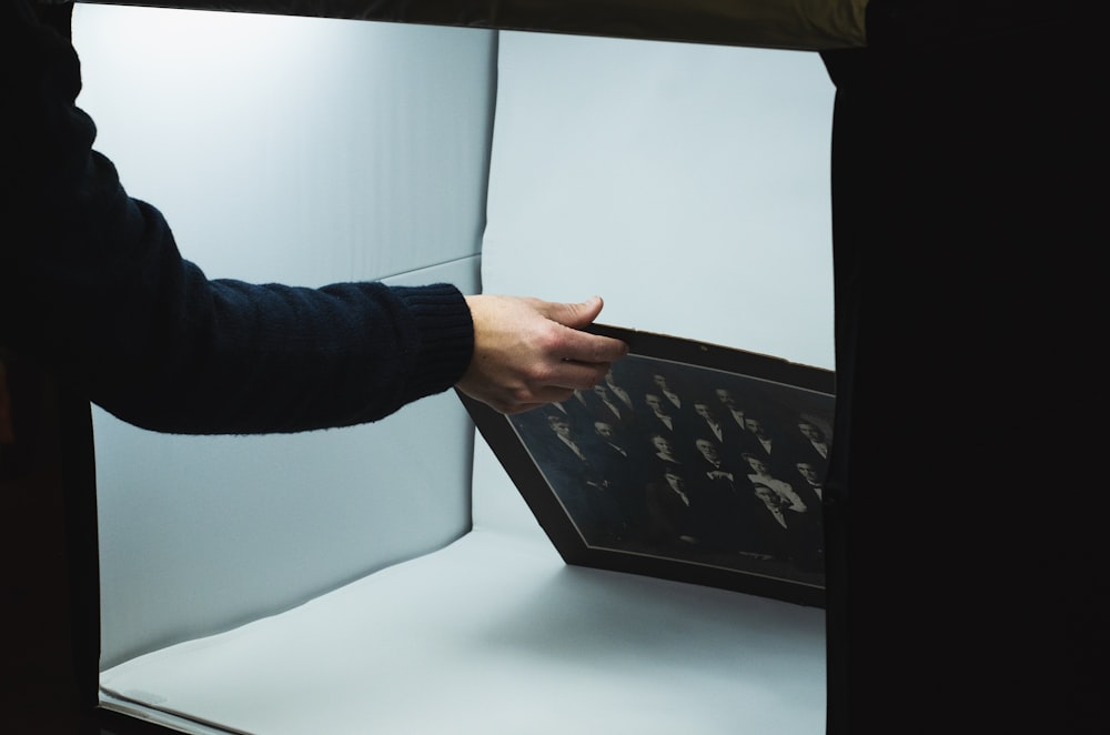 person holding black and gray paper