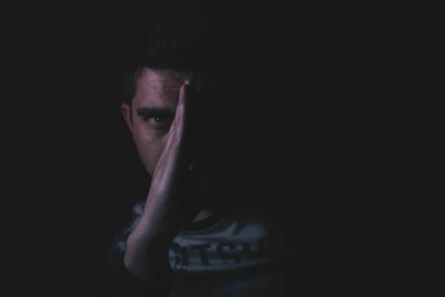a person smiling on the outside but with a shadowed face hinting at hidden feelings