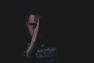 Close-up of a suspicious individual’s face partially obscured by shadows.