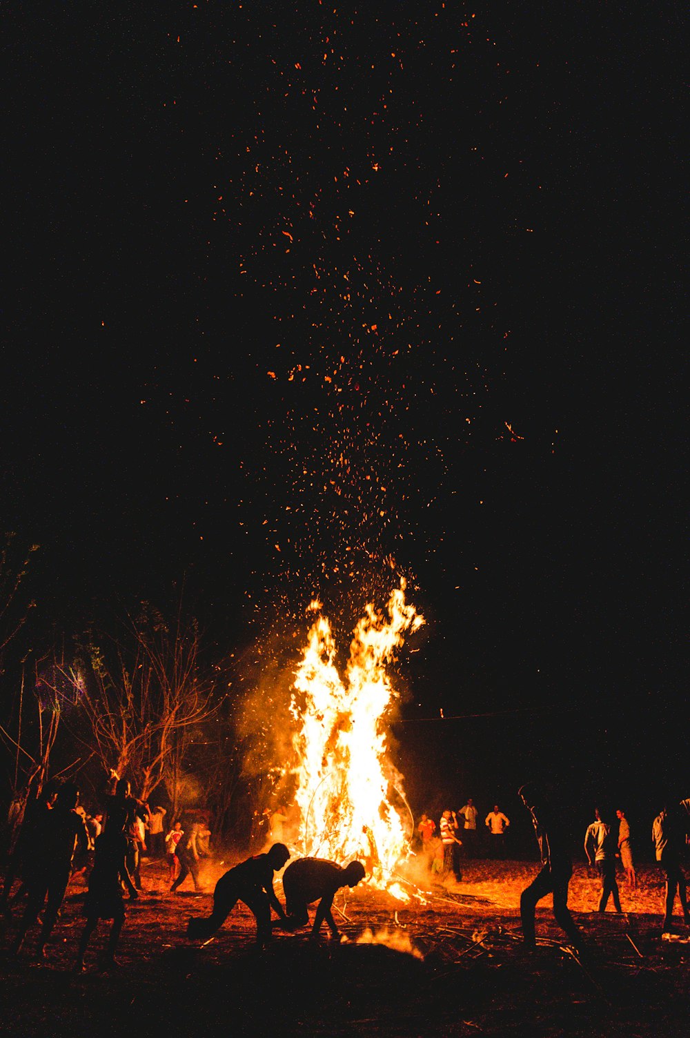 silhouette of people in front of lighted fire