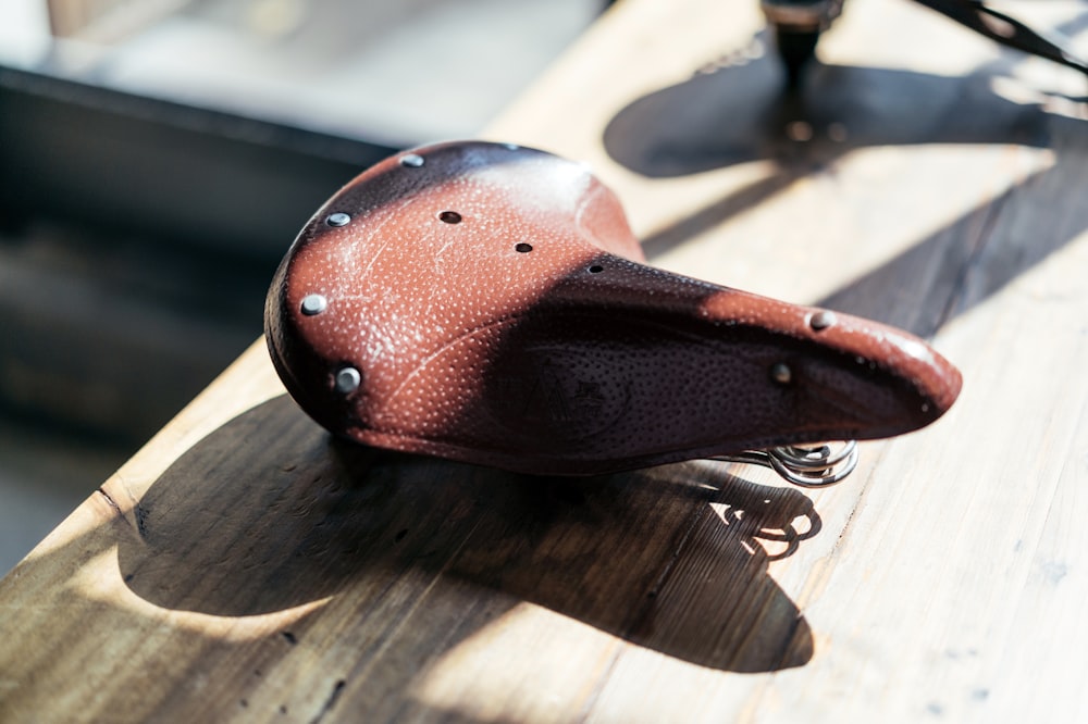 brown leather bicycle seat on brown wooden surface