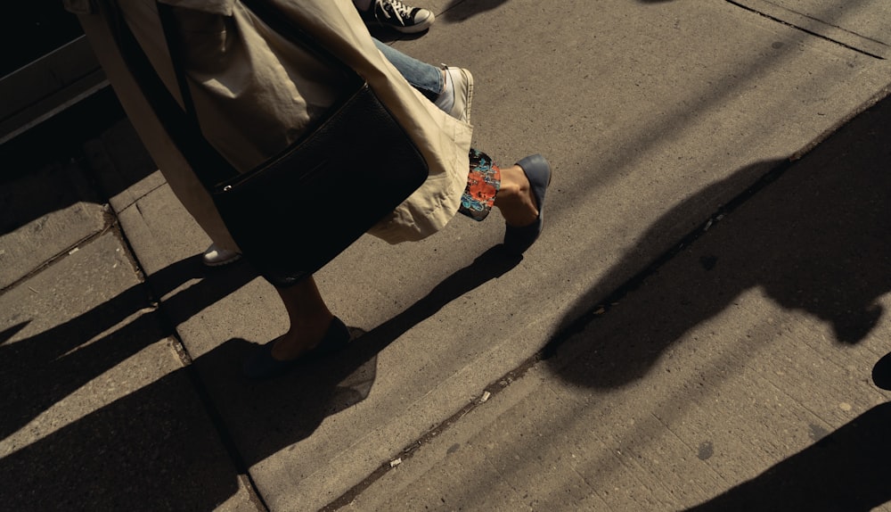 femme portant un sac à bandoulière en cuir noir