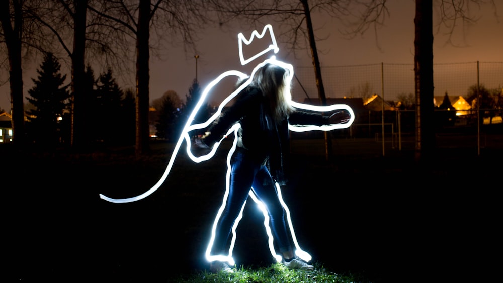 person with lined with white light walking on grass