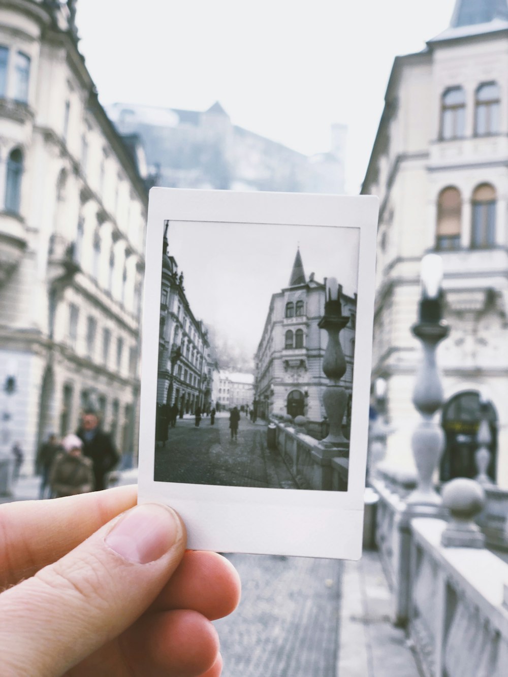 person holds photo of building