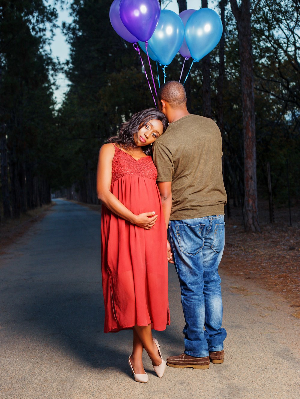 pregnant woman sitting next to man holding balloon