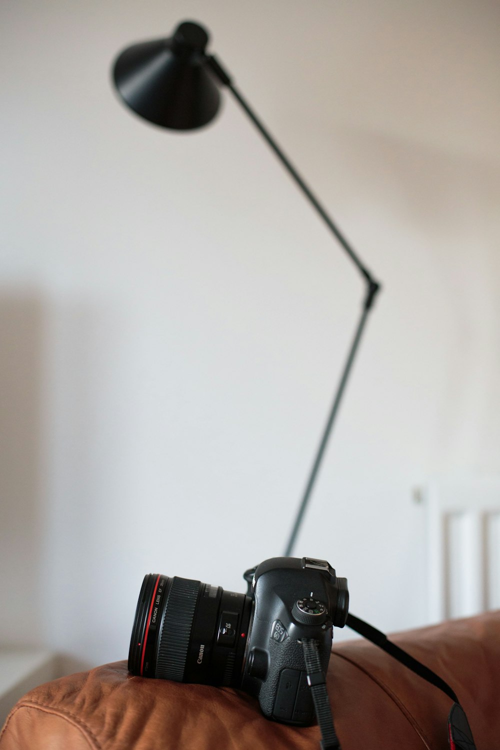 black DSLR camera on brown sofa