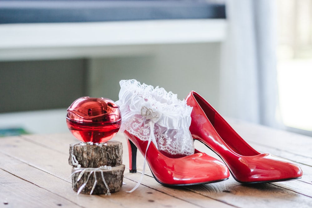 pair of red leather heels on wooden table