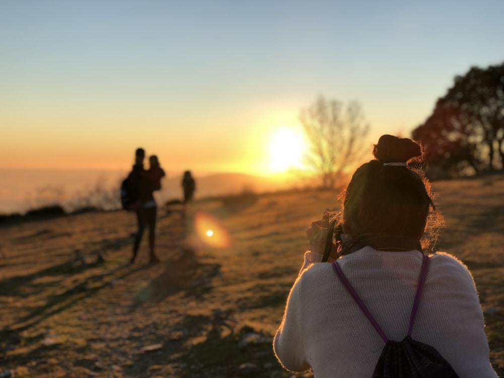 woman taking picture of man carrying a children