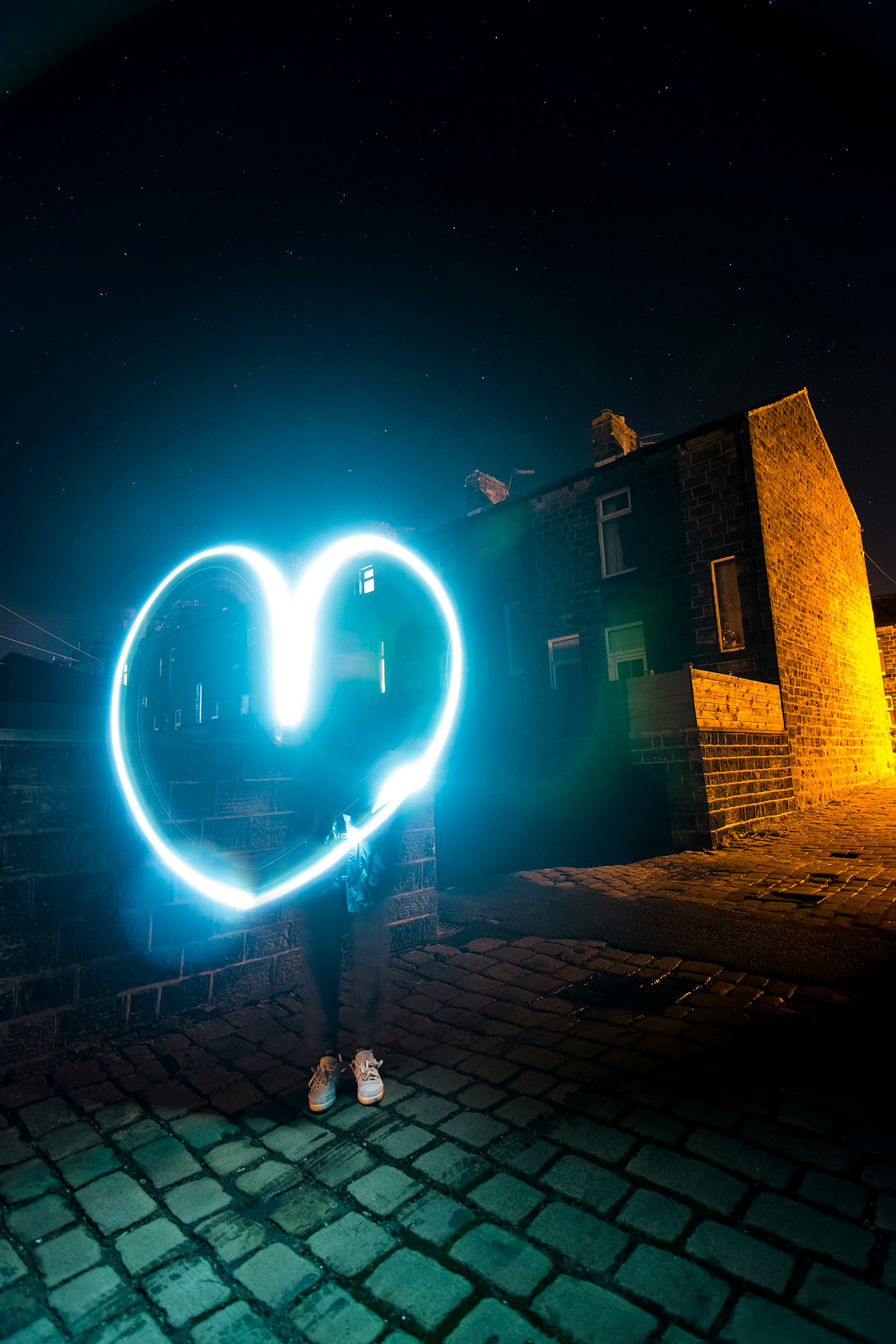 person holding heart wool fire beside building during nighttime