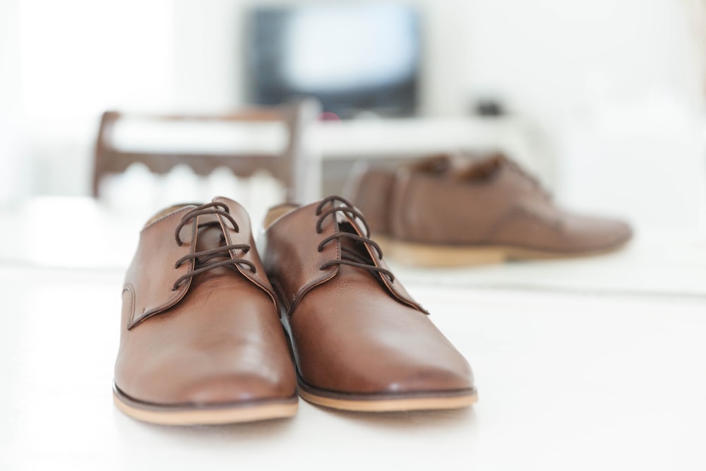 close-up photography of brown leather dress shoes