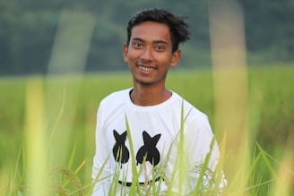 selective focus photography of man standing on green grass field during daytime
