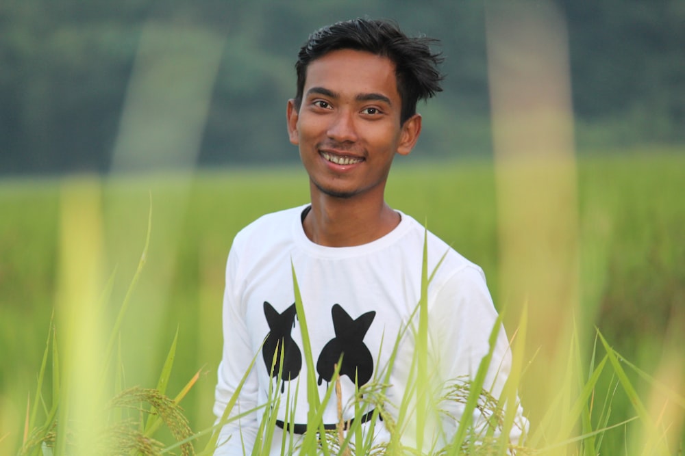 selective focus photography of man standing on green grass field during daytime