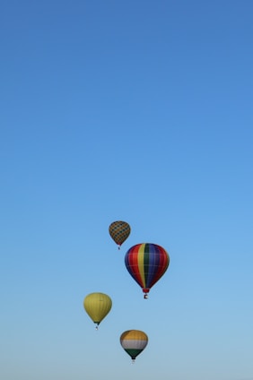 A group of students launching a high-altitude weather balloon against a clear blue sky.