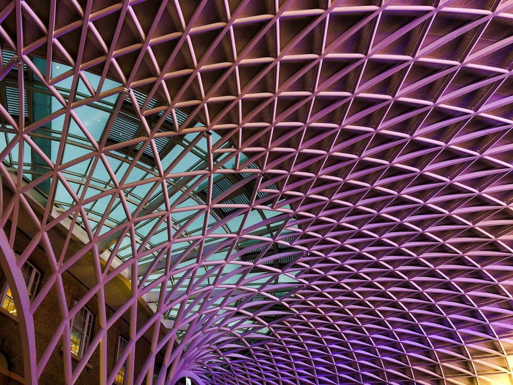 a train station with a purple ceiling and a clock