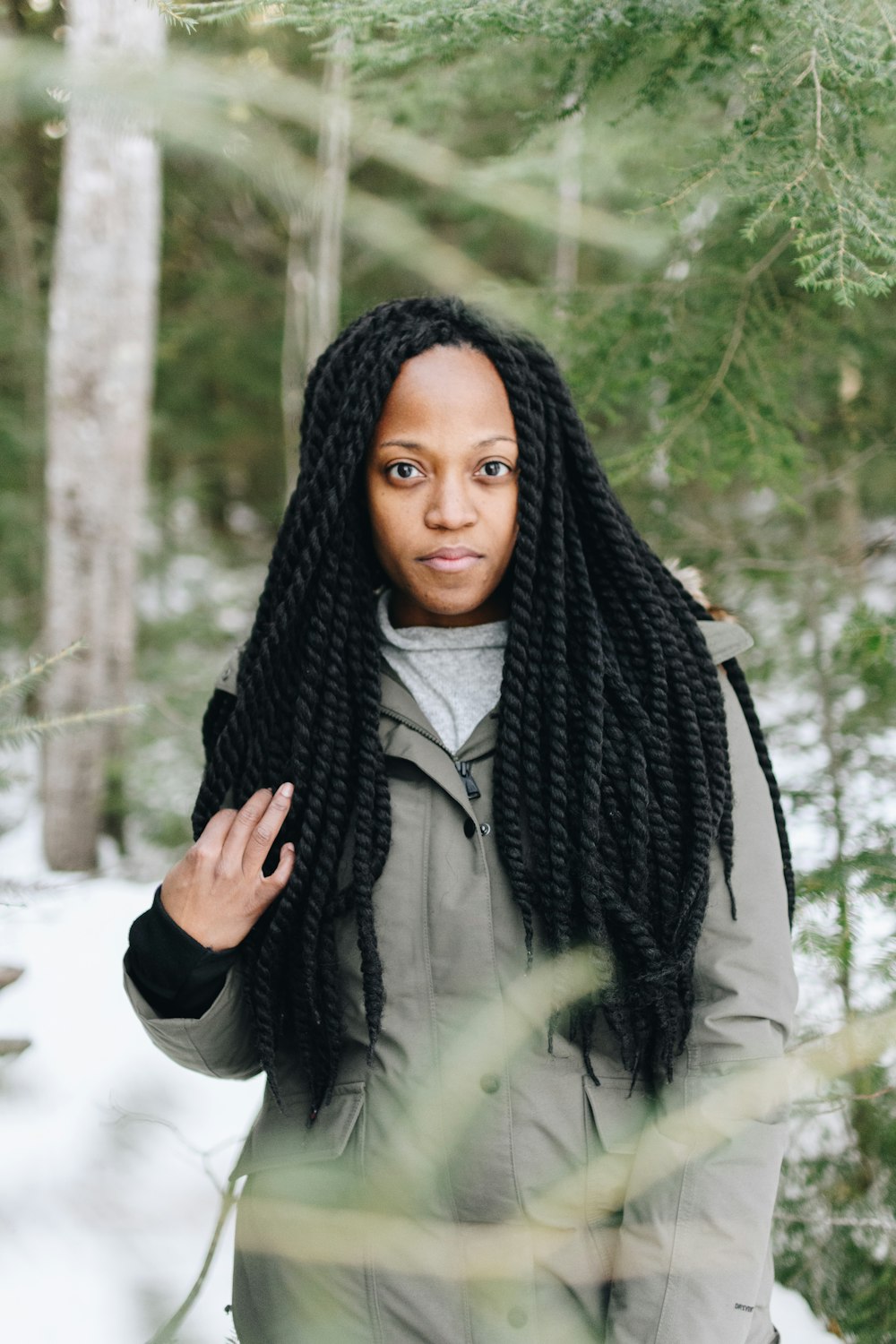 woman surrounded by snow under green trees