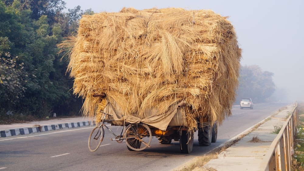 bicyclette accrochée à un tracteur plein de foin