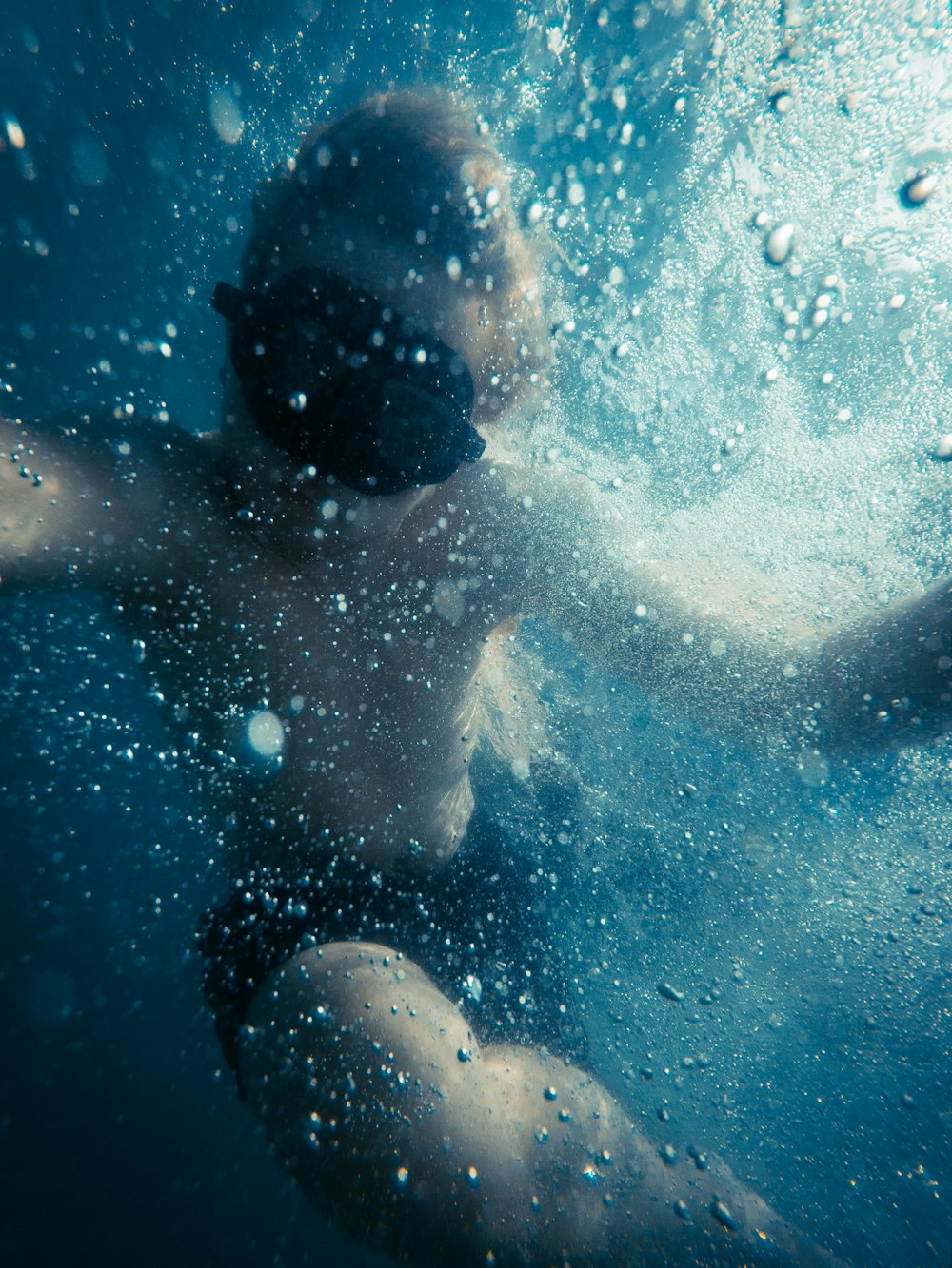 boy in black shorts under water