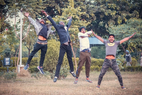 A lively group of friends shouting 'ietta' with joyful expressions outdoors.