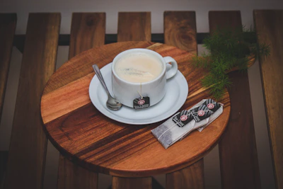 A steaming cup of coffee sweetened with naturalose, with a spoonful of granulated sweetener beside it.