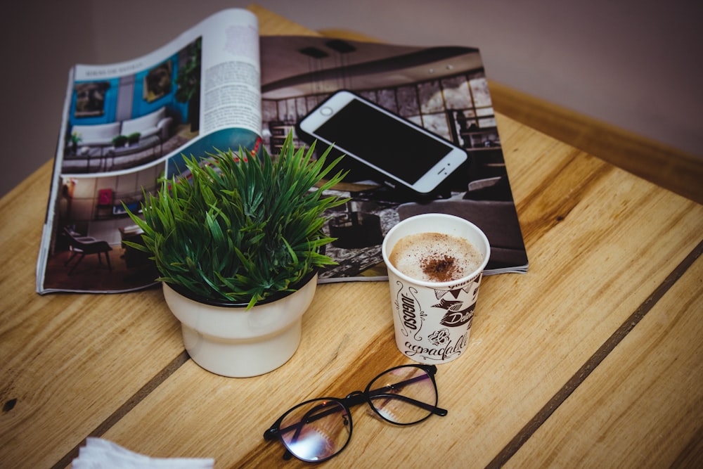 eyeglasses beside cup of latte and iPhone 6