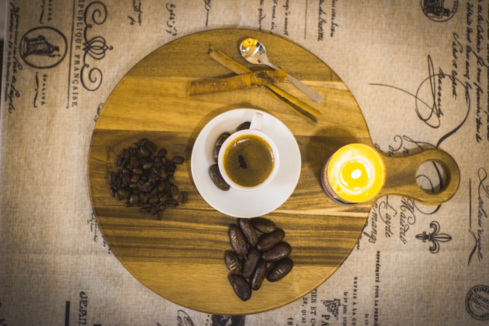 coffee beans beside cup and saucer with coffee