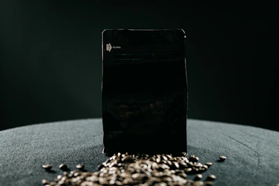 Premium coffee packaging with gold foil details resting on a dark textured surface.