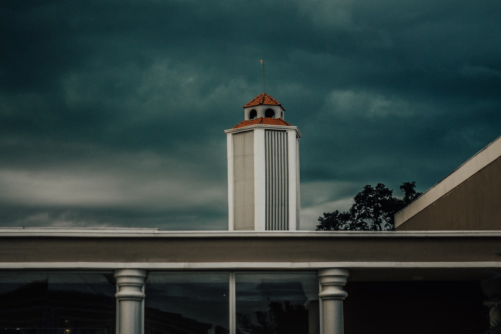 white tower house under nimbus clouds